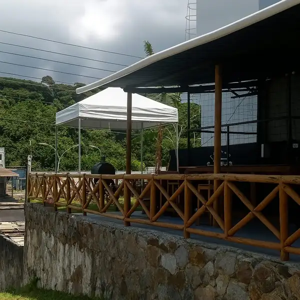 Tenda branca montada em área externa com deck de madeira